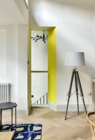 White walls, neon yellow archway, wooden floor