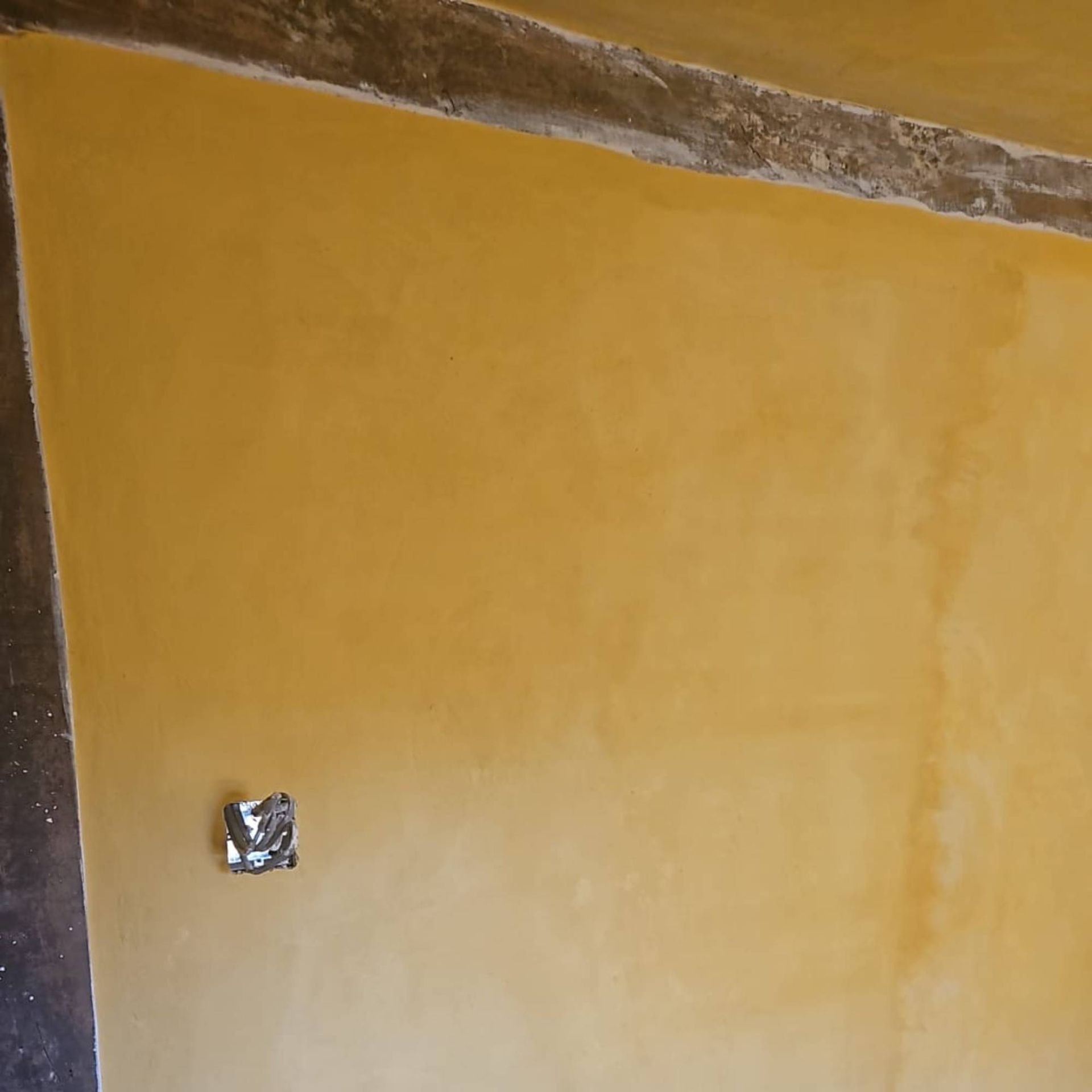 yellow paint on lime wall with timber beams