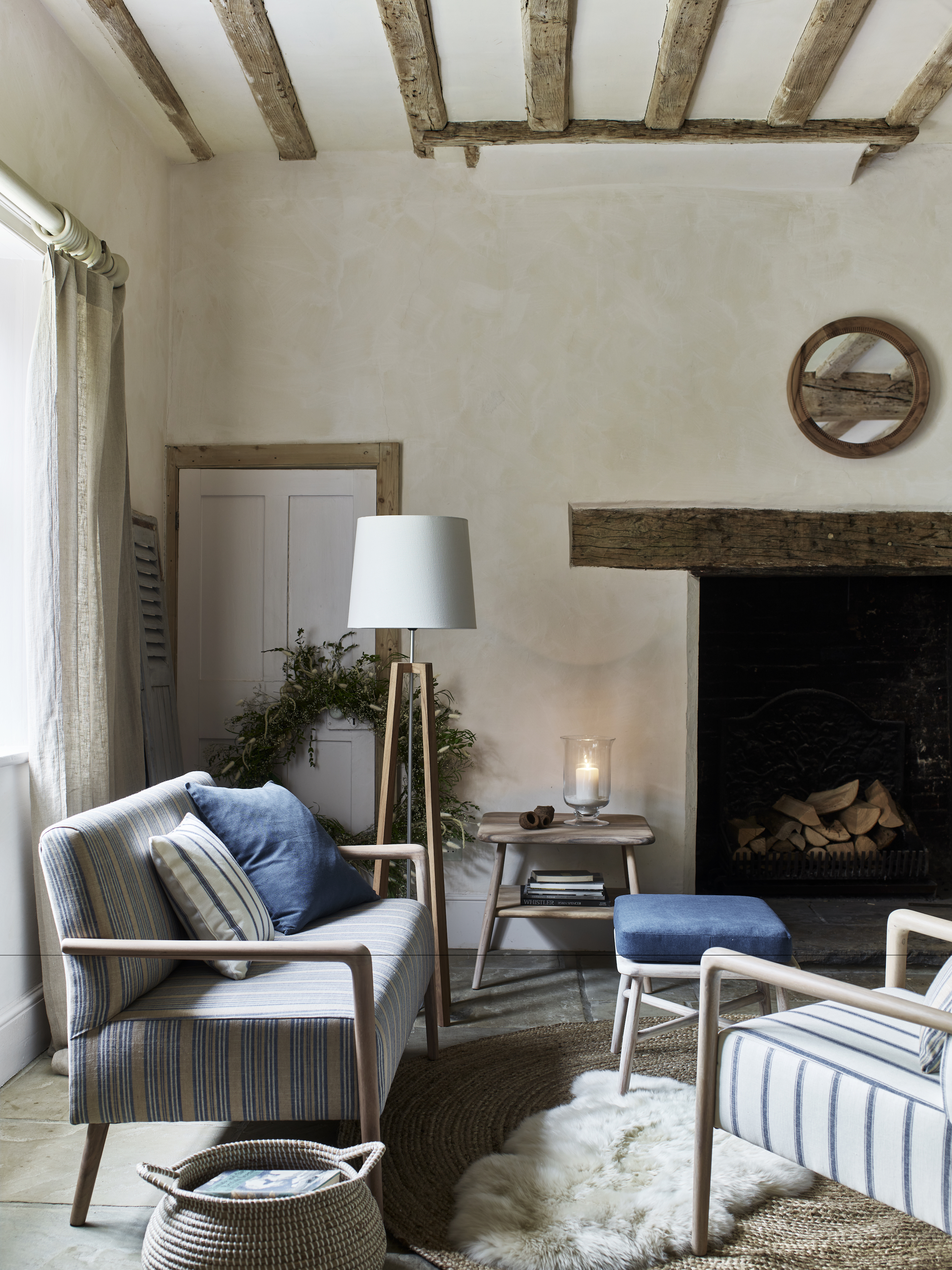 living room with beams and fireplace, sofa, armchair and rug