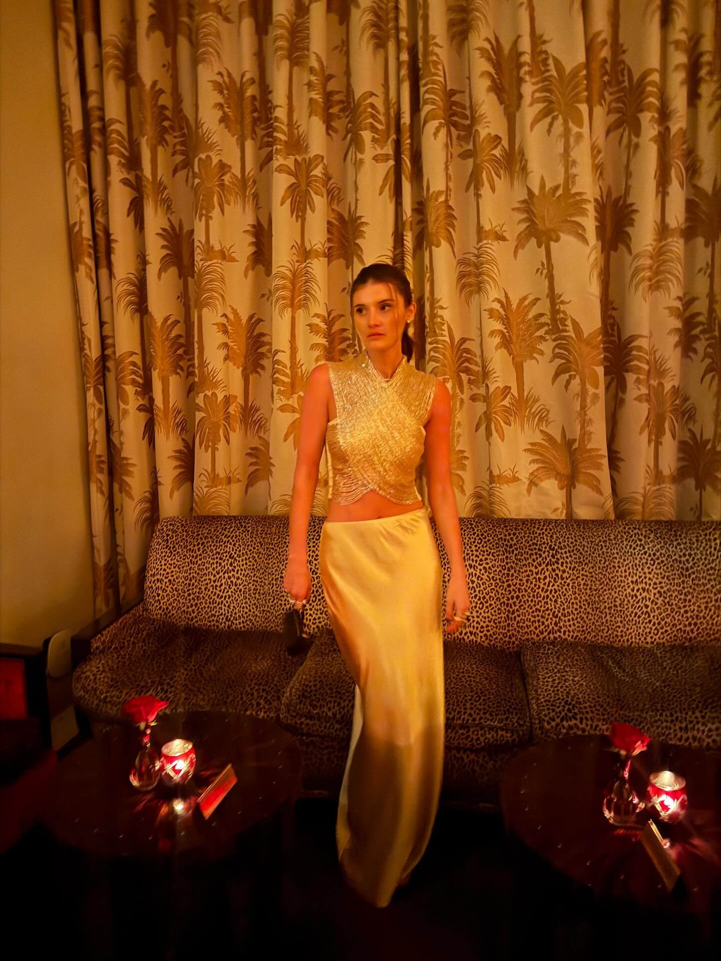 Coco wears a silver top and silver slip skirt.