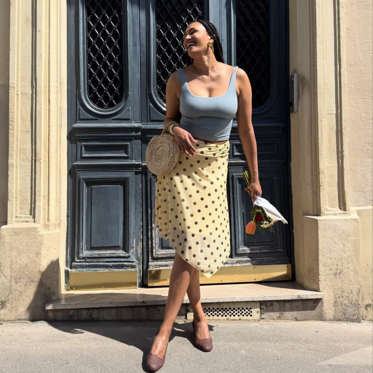 Influencer Lena Farl wearing a cropped vest top, polkadot skirt and ballet flats. 