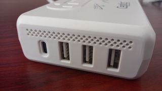 Side view of Ceptics 220V to 110V Travel Voltage Converter on desk, showing USB ports