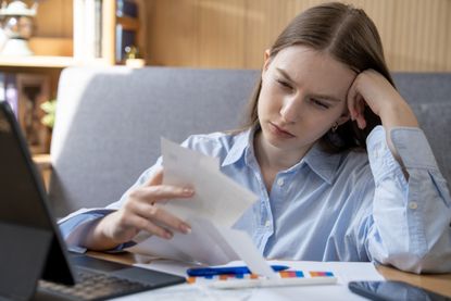Young woman looking at bills
