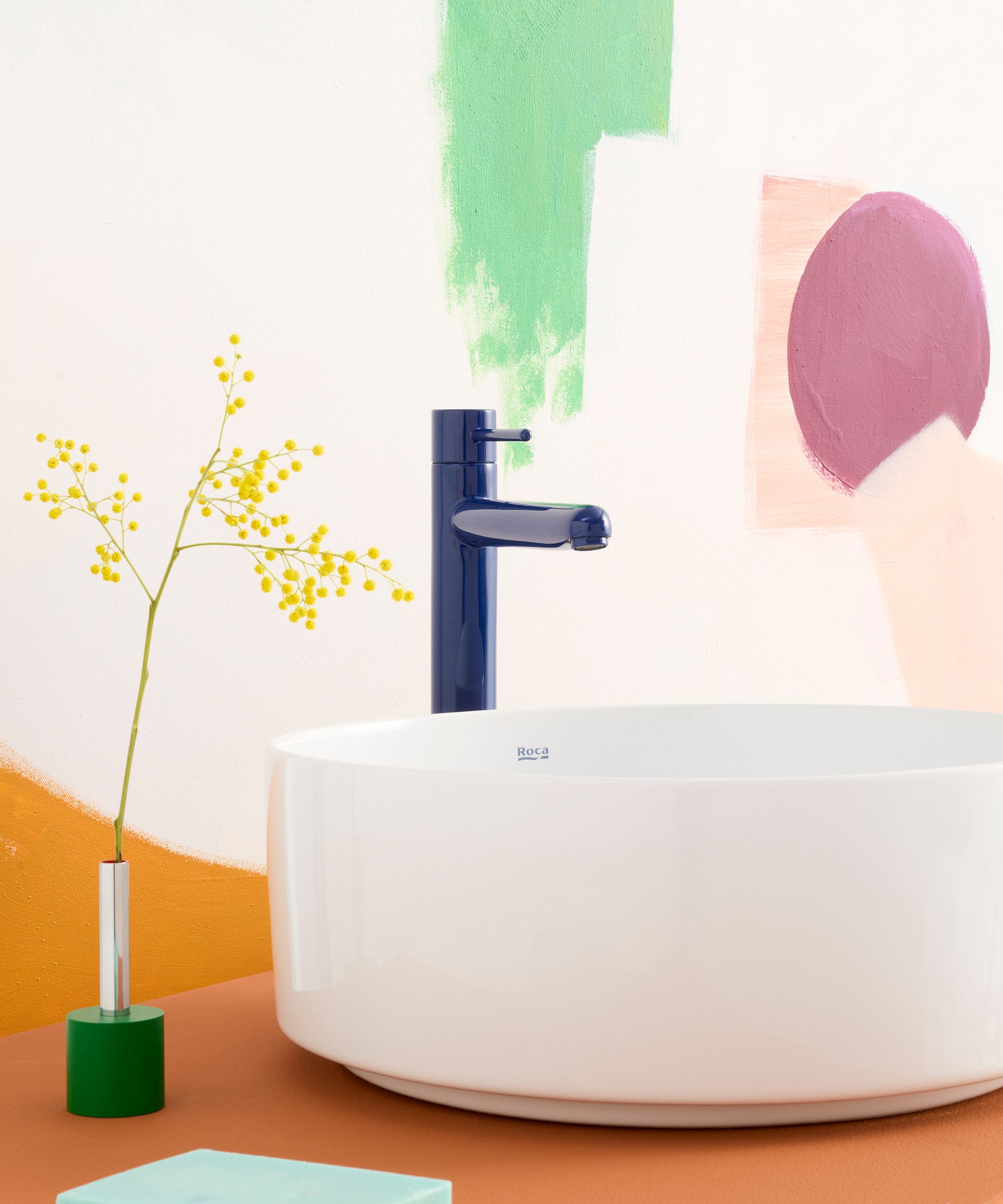 Colorful brassware and textured surfaces are the unexpected bathroom