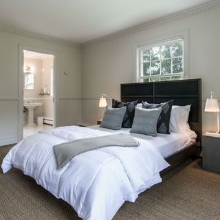 bedroom with white walls and white bed with pillows