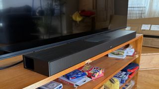 The Zvox AccuVoice AV855 soundbar pictured on a wooden cabinet underneath a TV