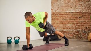Man performing renegade row exercise with dumbbells