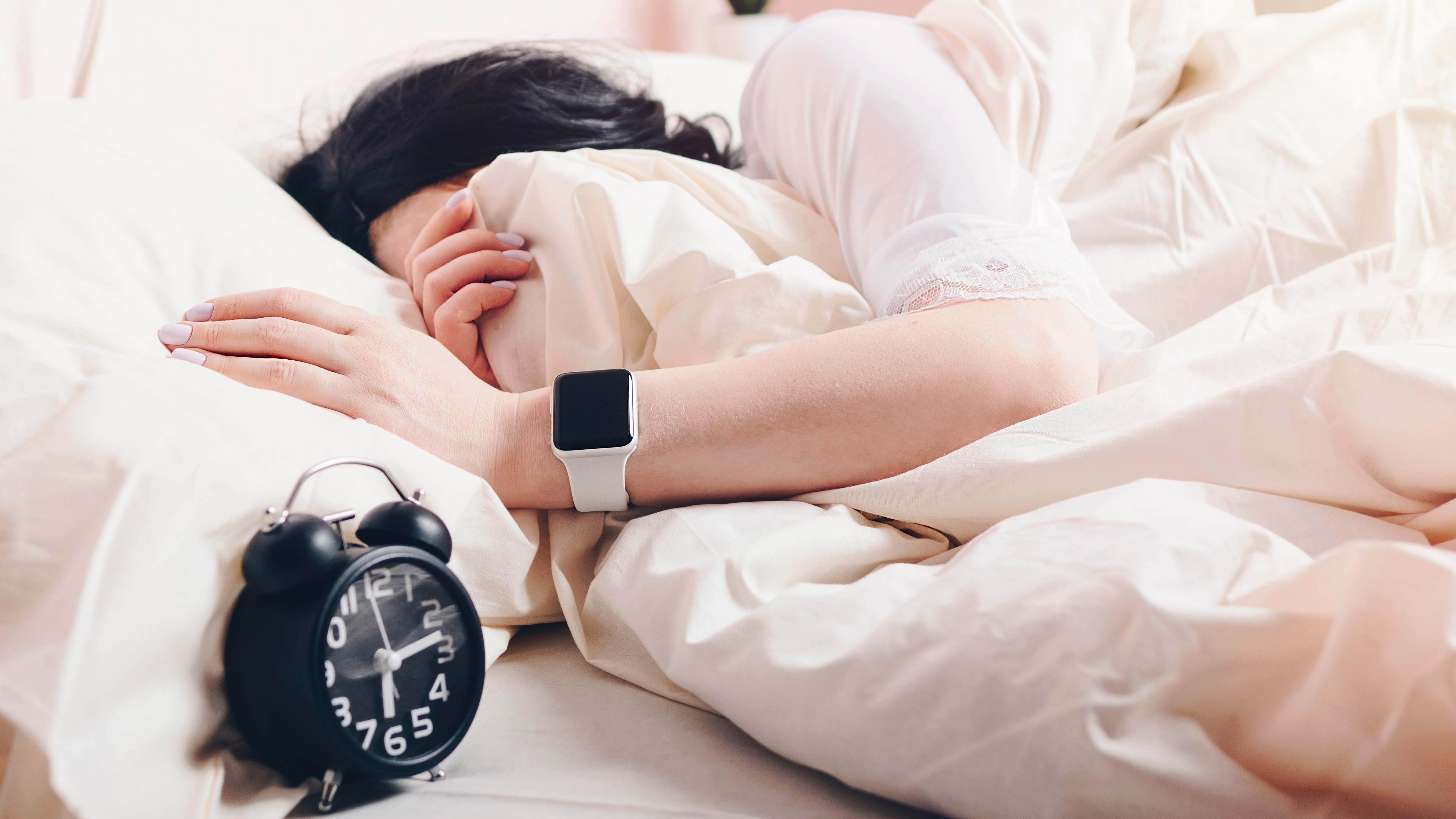 Woman in bed wearing Apple Watch
