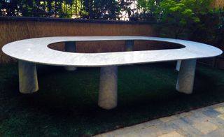 Outdoors ‘Arena’ style table with an open middle and six legs.