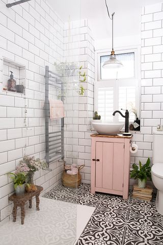 Bathroom with shower enclosure, patterned floor tiles and a pink wooden basin unit