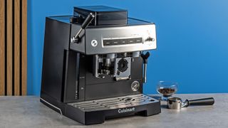 the cuisinart grind, tamp and brew espresso machine with built-in grinder photographed against a blue tom's guide background