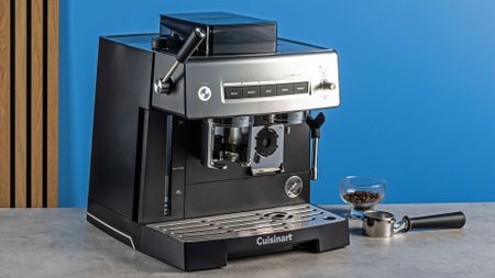 the cuisinart grind, tamp and brew espresso machine with built-in grinder photographed against a blue tom's guide background