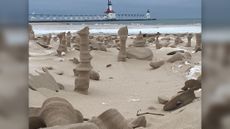 Sand sculptures decorate the shore by Lake Michigan at Tiscornia Park, with the North Pier Lighthouse in the background in St. Joseph, Michigan.