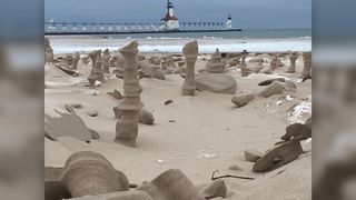 Sand sculptures decorate the shore by Lake Michigan at Tiscornia Park, with the North Pier Lighthouse in the background in St. Joseph, Michigan.