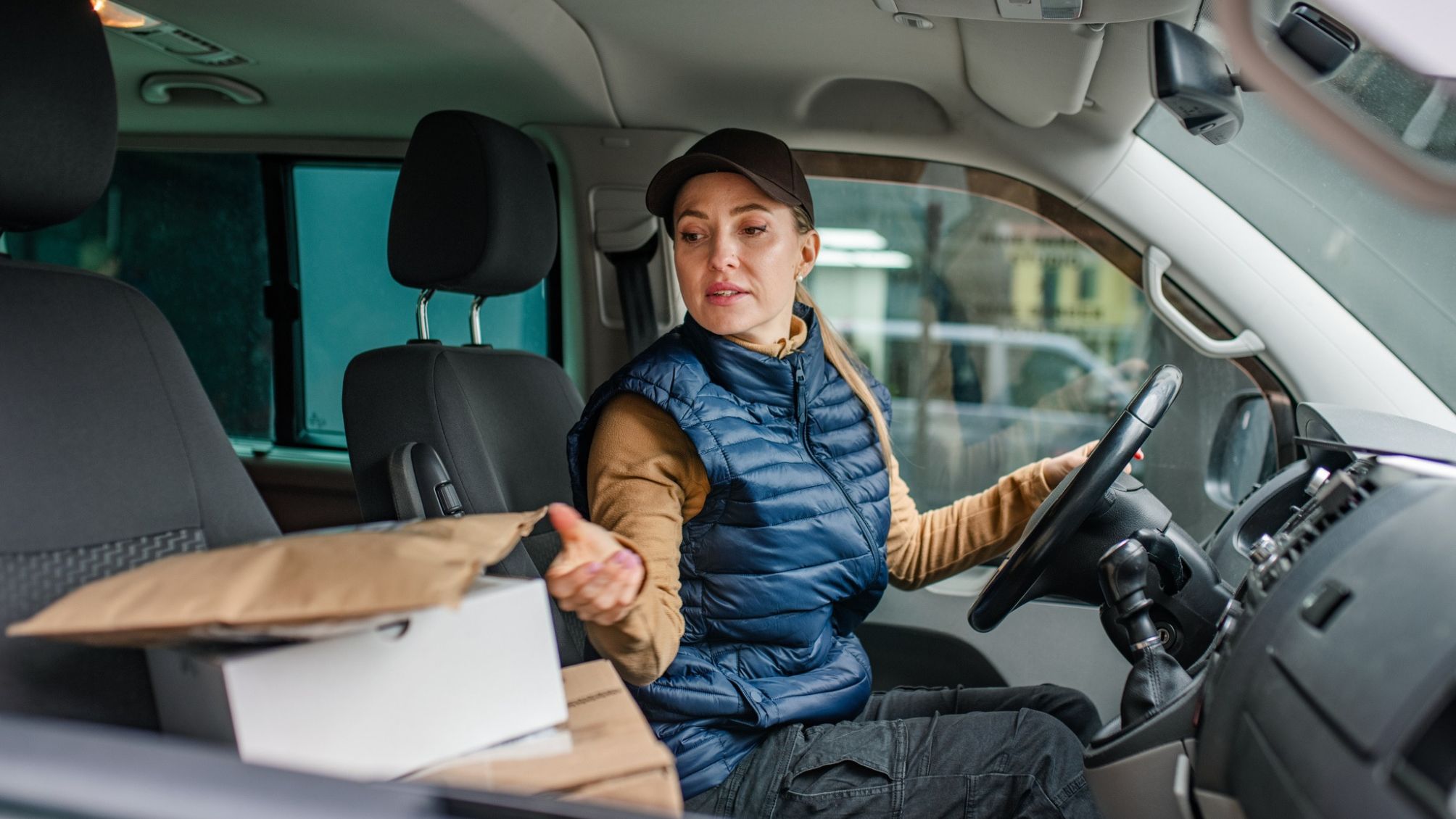 A woman delivering packages in her car. 