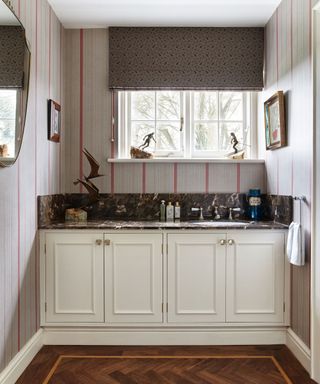 An example of traditional powder room ideas showing a built in vanity with cabinets and a sink
