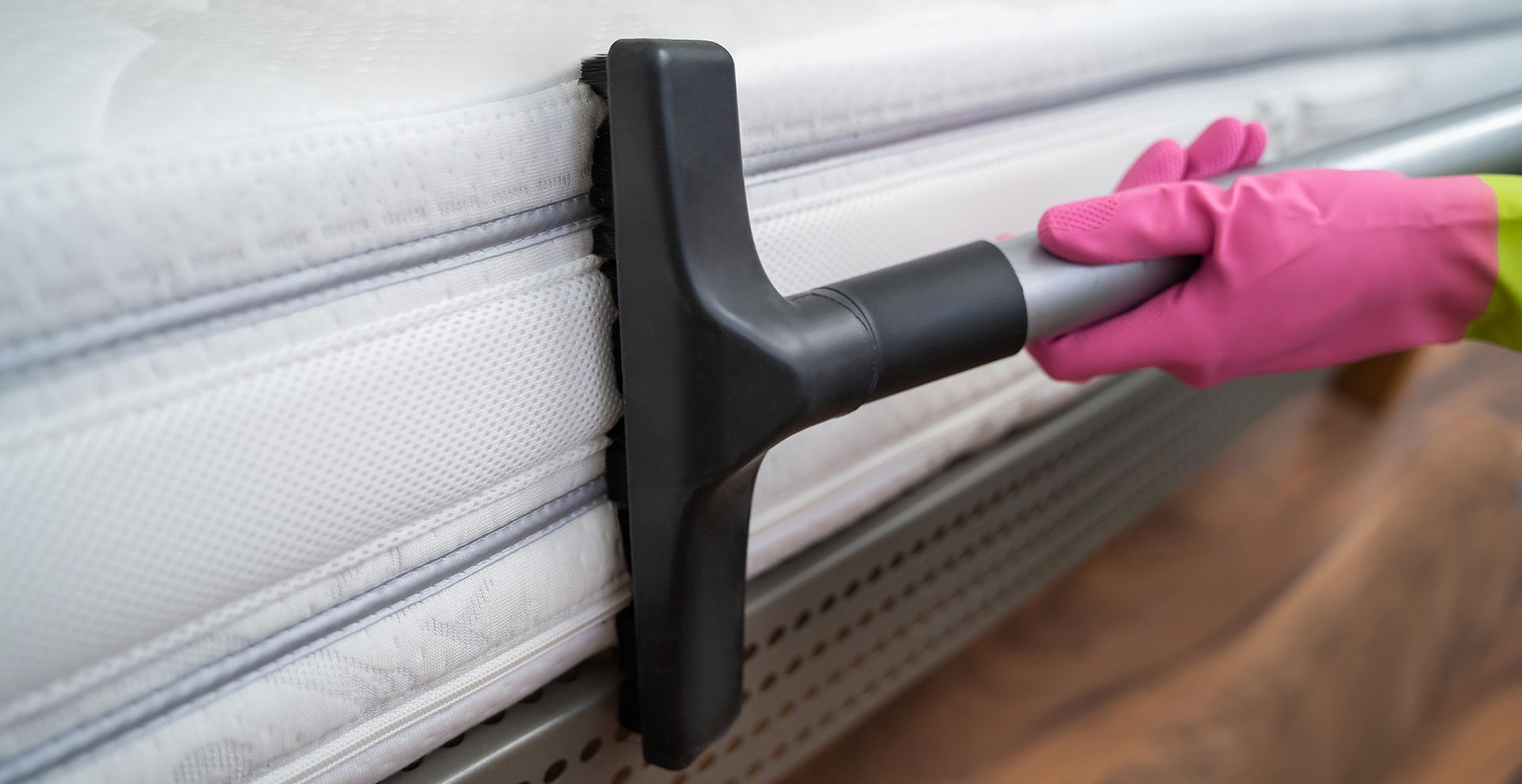 vacuuming a mattress on all sides to show how to deep clean a mattress