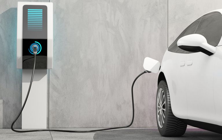 An electric car charging to illustrate the pros and cons of electric cars