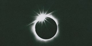 A total solar eclipse, seconds before totality, when a single bead of the sun's disk is still visible.