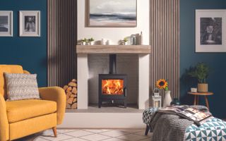 Wood burning stove central in teal living room with upholstered fabric couches