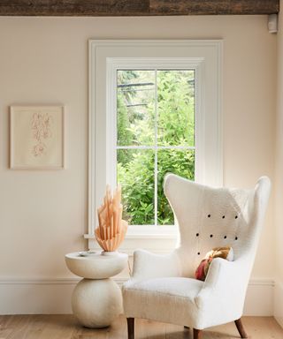 living room with white walls and white wingback armchair
