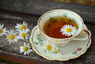 teacup with tea and daisies