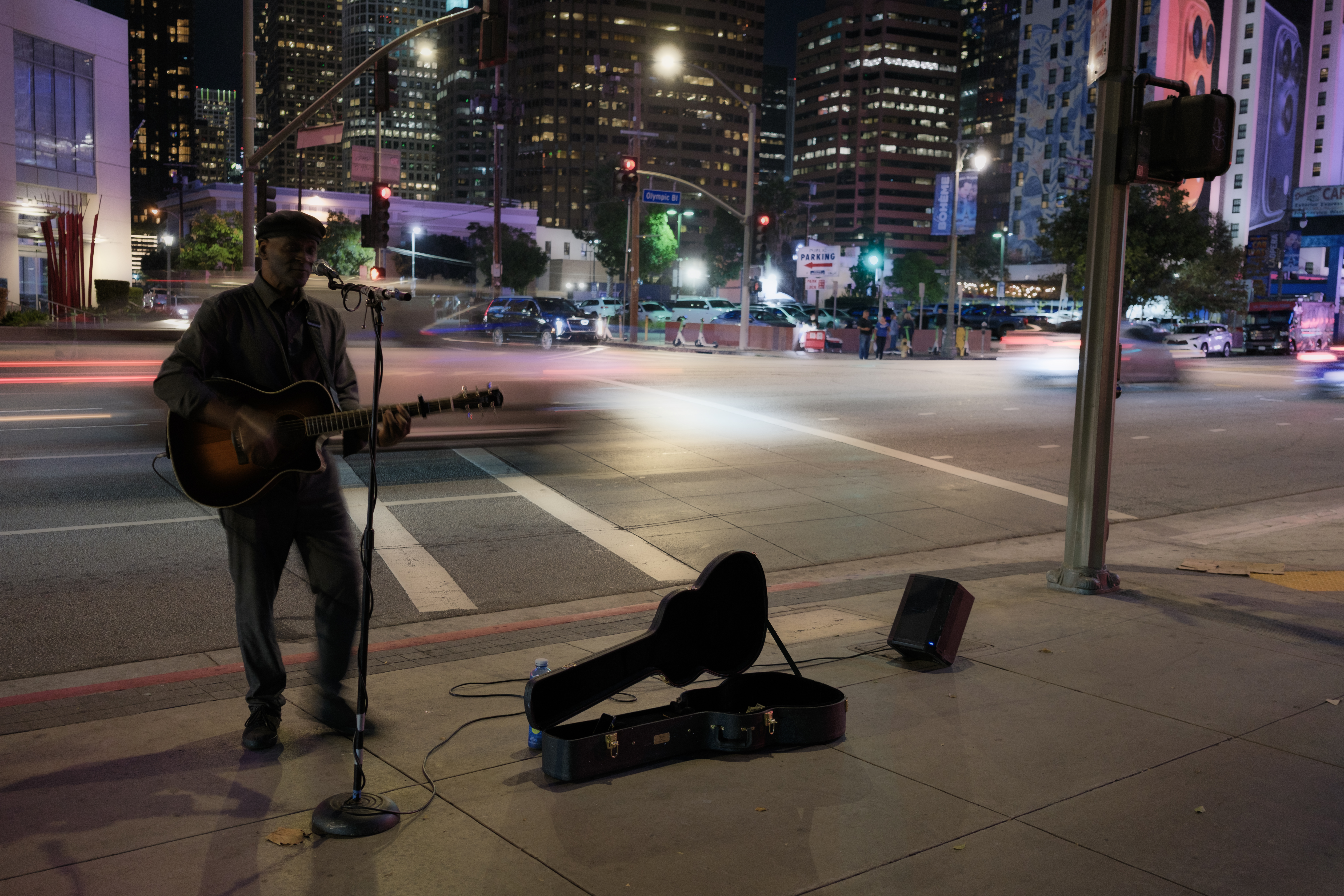 A street performer at night, with blurred traffic in the streets, edited in Adobe Camera RAW