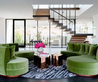 living room with staircase and green sofa