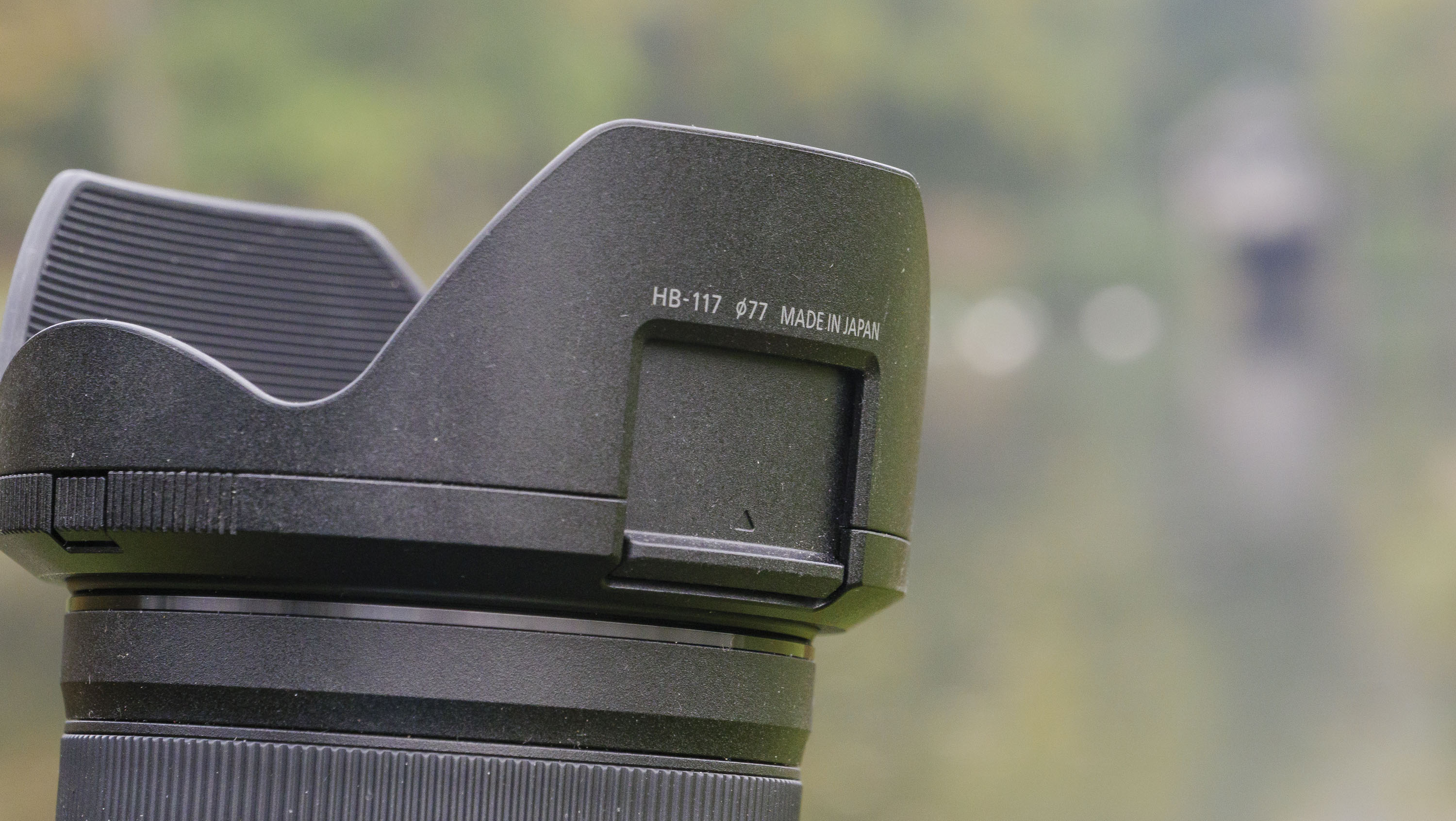 Closeup of the Nikon Z 24-70mm f/2.8 S II lens' lens hood with filter hatch open