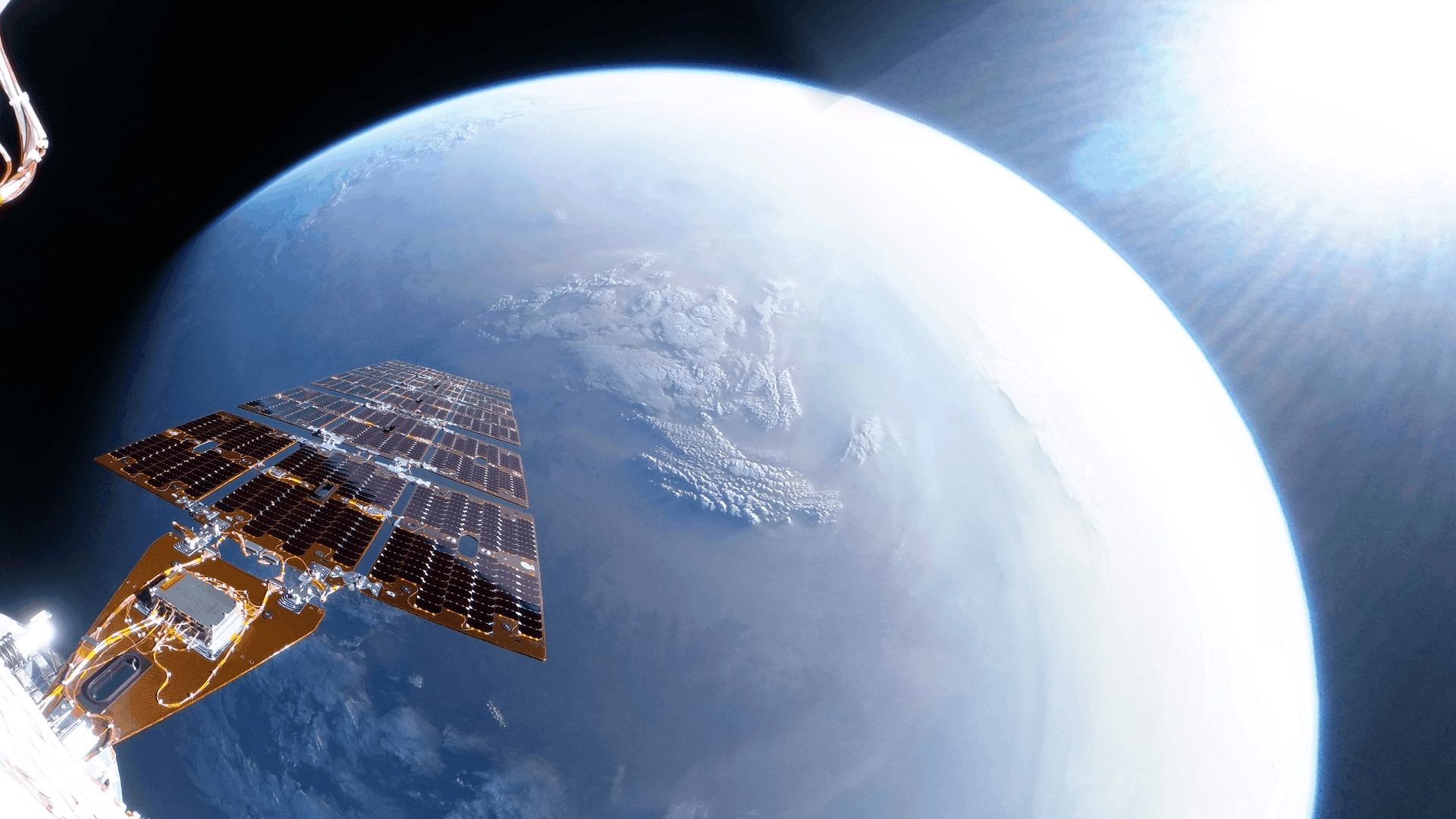 selfie taken by a spacecraft showing one of its solar panels with earth in the background