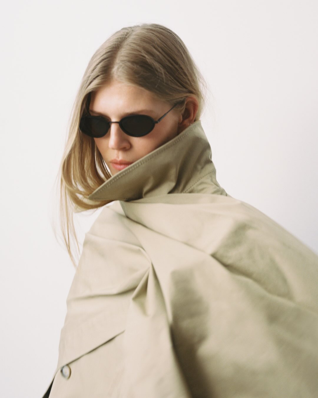 Campaign shot from House of Dagmar featuring a model wearing a trench coat and sunglasses.