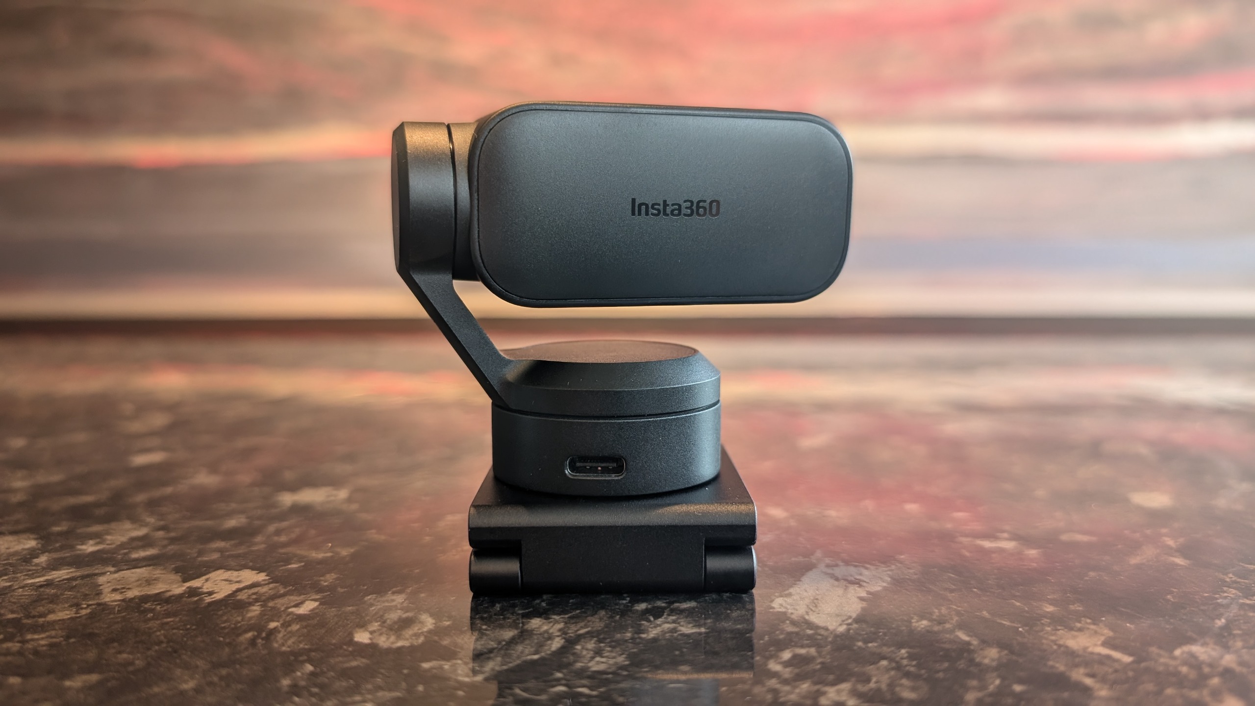 The Insta360 Link 2 Pro webcam, pictured on a marble worktop.