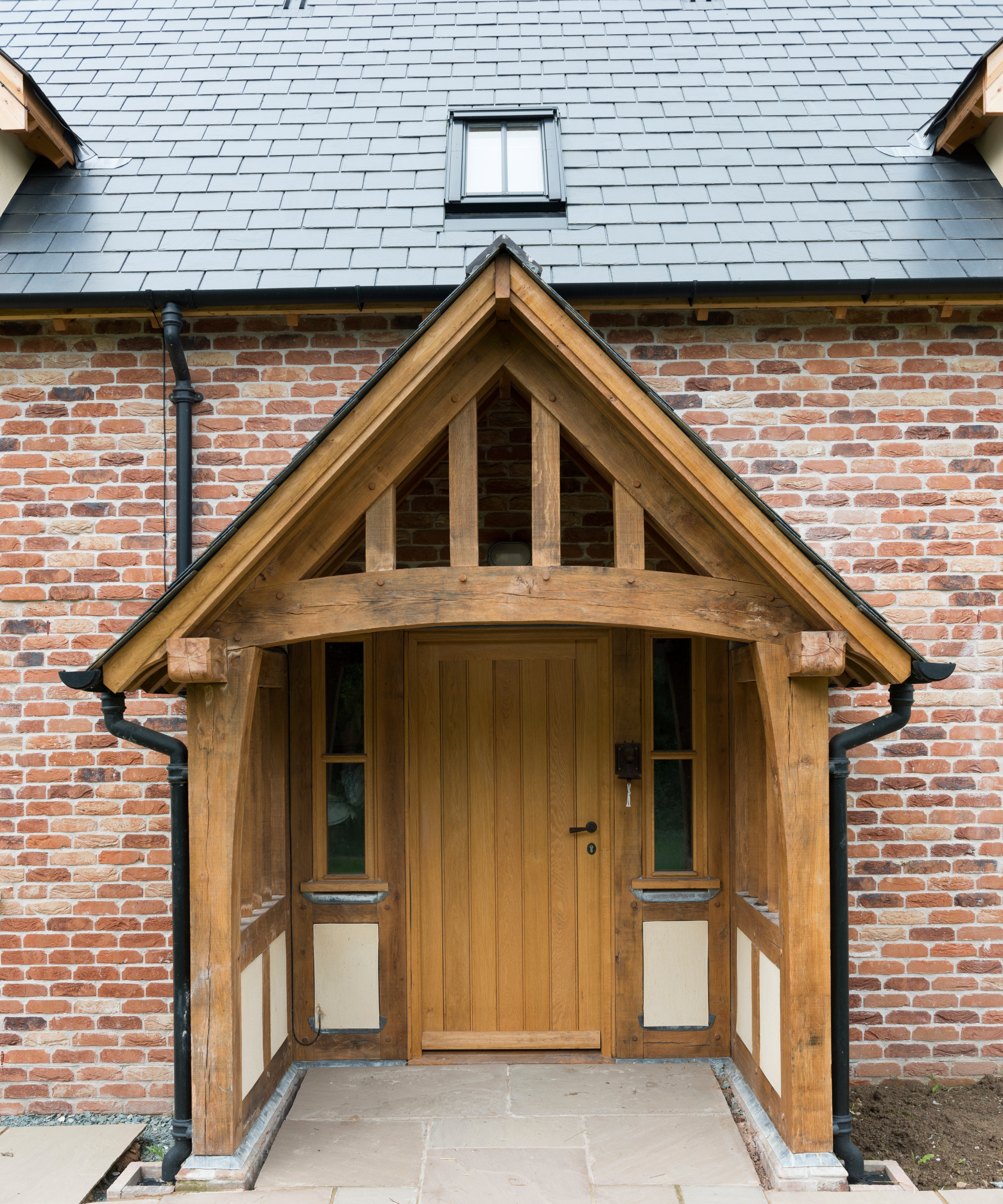 oak frame porch on brick house with black slate roof more modern in design