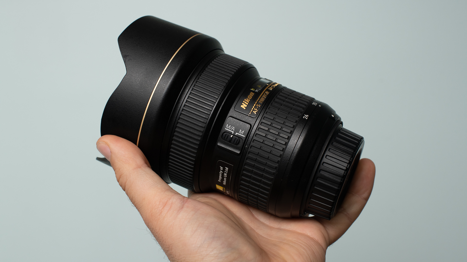 Image shows the Nikon AF-S 14-24mm f/2.8 ED in a person's hand.