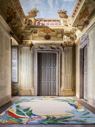Colourful rug on floor of historical palazzo with frescoed ceiling