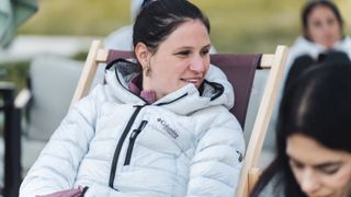 A women in a white down jacket sitting in a deck chair