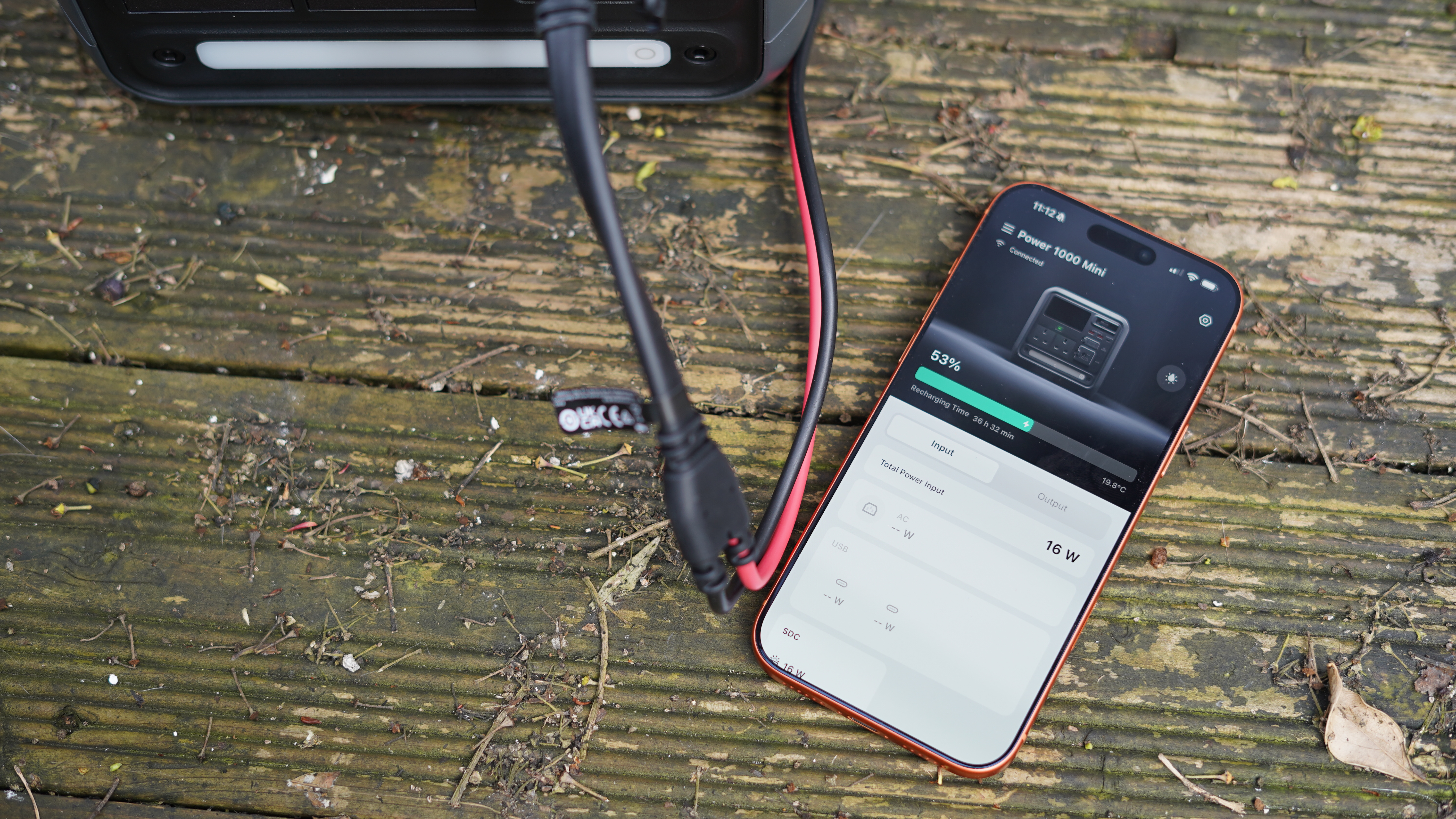 DJI Power 1000 Mini and the DJI Home app on an orange iPhone 17 showing how much charge is currently flowing in