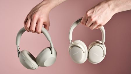 Person holding Sony WH-1000XM6 and Bose QuietComfort Ultra