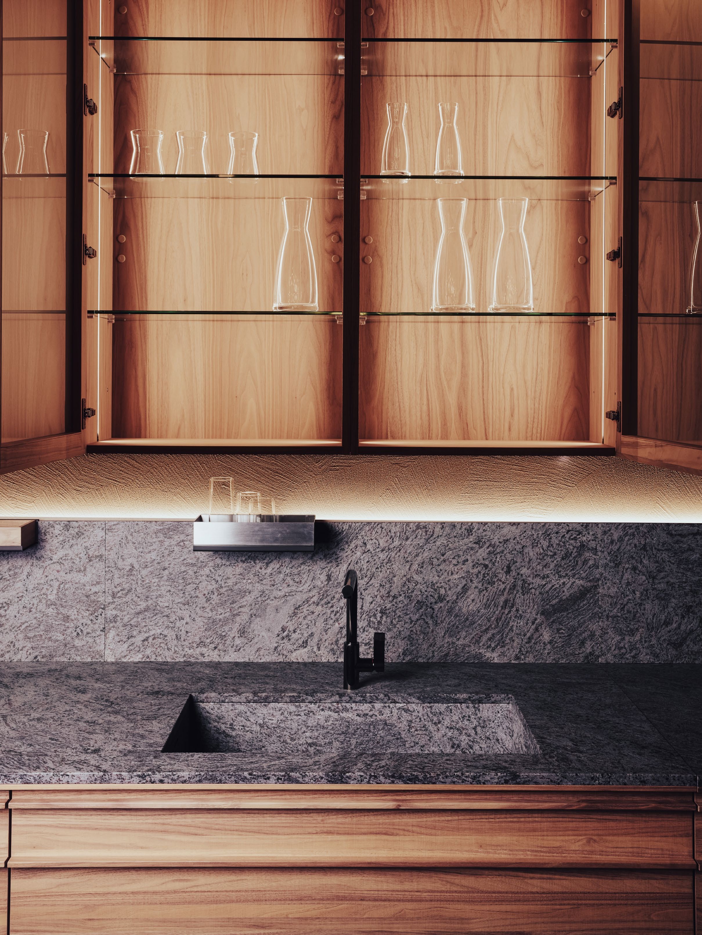 stone kitchen with backlit wooden cabinets
