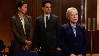 Leah Lewis David Del Rio and Kathy Bates stand lined up together in the back of a courtroom in Matlock: S1 E6 - "Sixteen Steps."