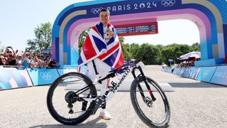 Tom Pidcock at the finish line posing with his Pinarello Dogma XC