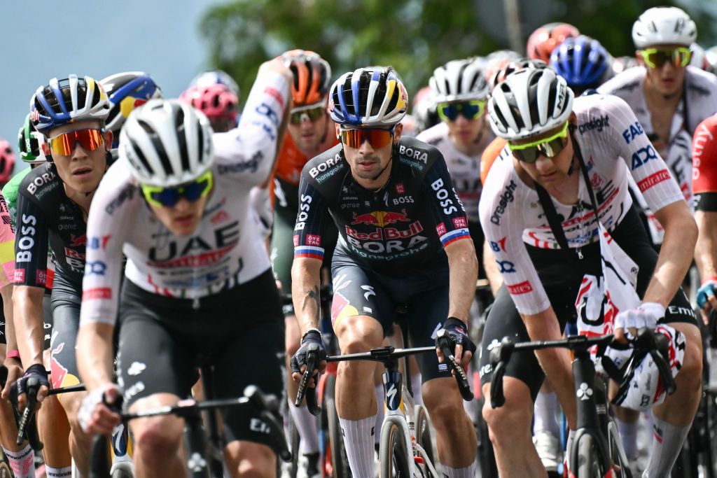 Red Bull - BORA - hansgrohe team's Slovenian rider Primoz Roglic (C) cycles with the pack of riders (peloton) during the 1st stage of the 111th edition of the Tour de France cycling race, 206 km between Florence and Rimini, in Italy, on June 29, 2024. (Photo by Marco BERTORELLO / AFP)