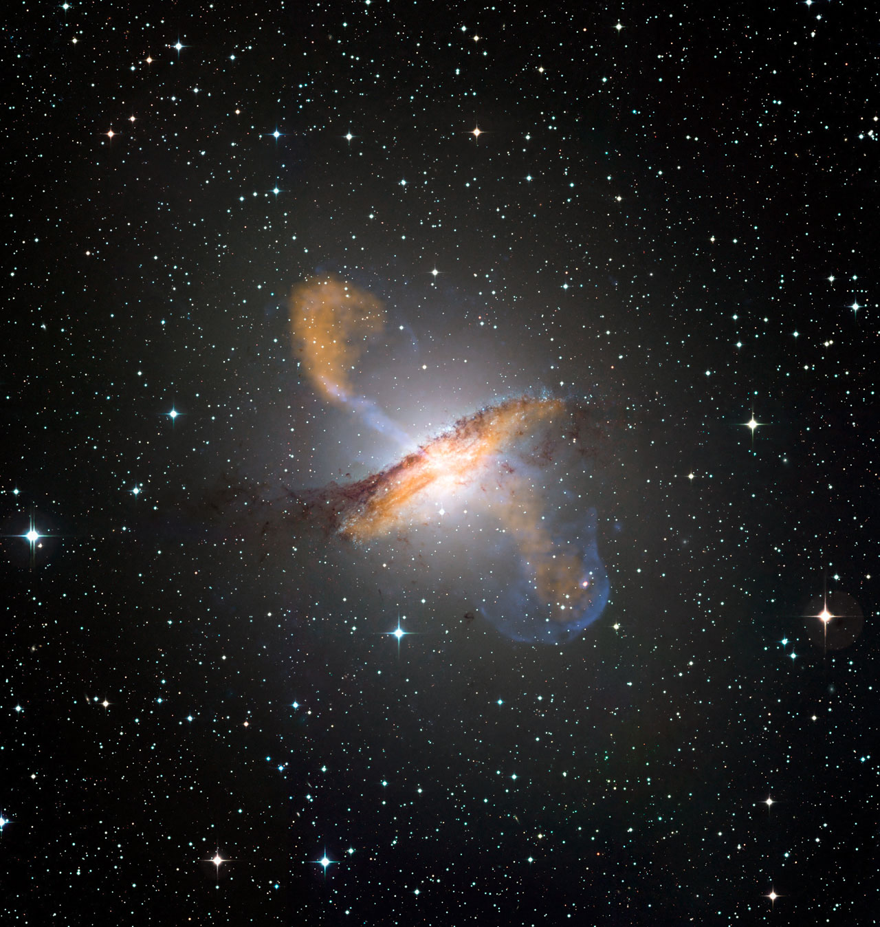 Merging X-ray data (blue) from NASA’s Chandra X-ray Observatory with microwave (orange) and visible images reveals the jets and radio-emitting lobes emanating from Centaurus A&#039;s central black hole. 