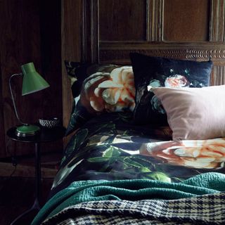 bedroom with floral beddings and green lamp