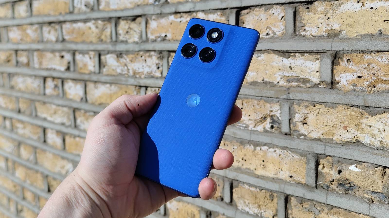 The Motorola Edge 60 Pro above a brick wall.