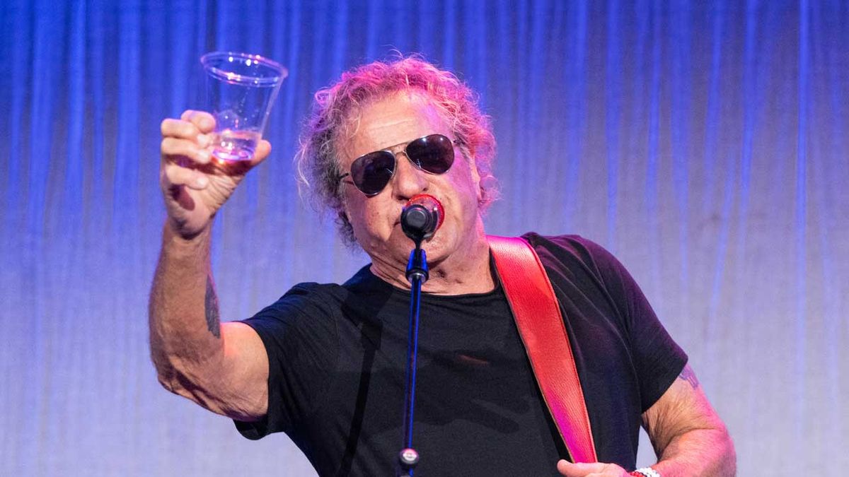 Sammy Hagar onstage, raising a drink in salute