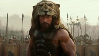 Dwayne Johnson stands ready for battle while wearing a lion pelt in Hercules.