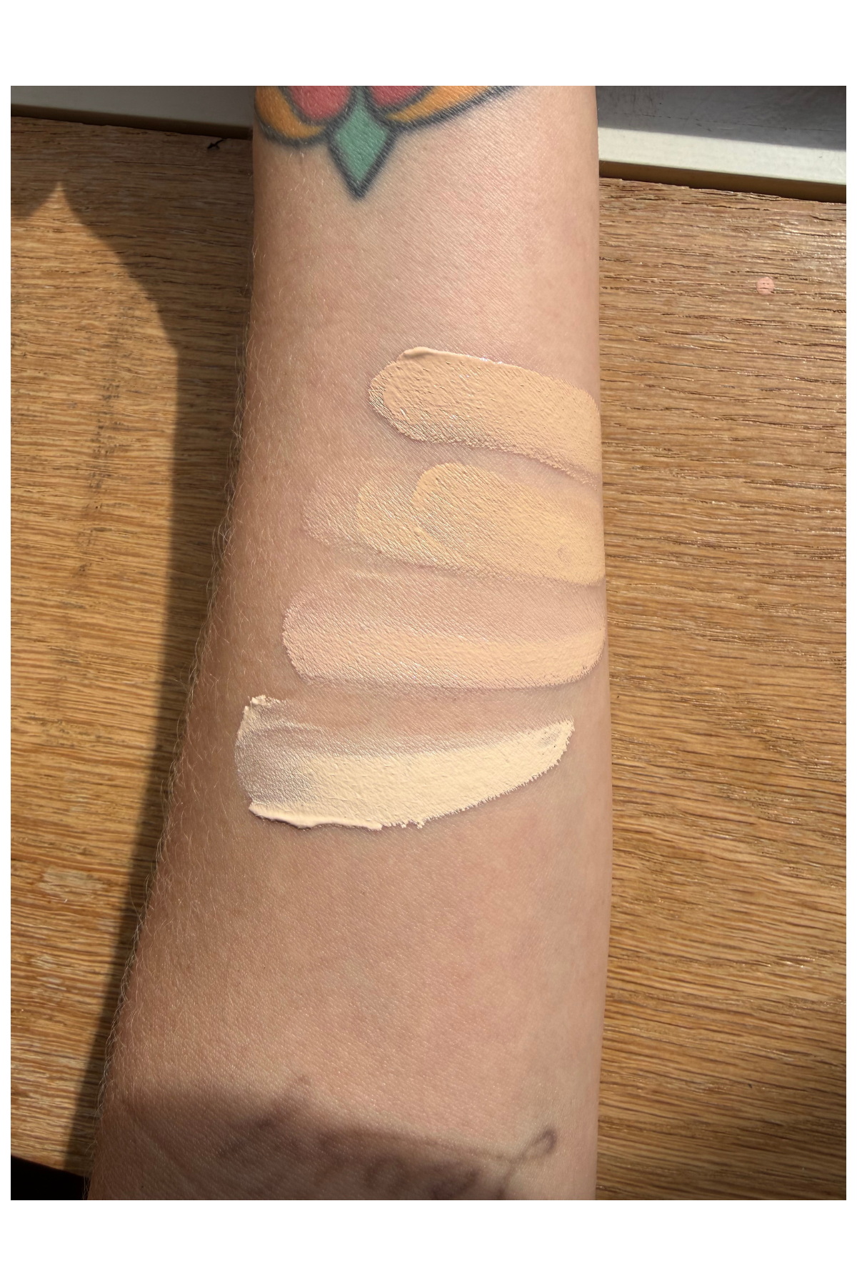 a white forearm with four swatches of cream foundation across it