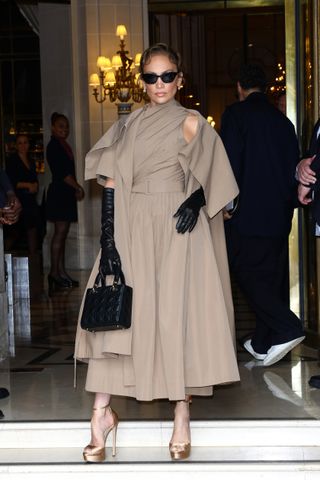 Jennifer Lopez wears a khaki dress and elbow length gloves at the dior couture show in paris