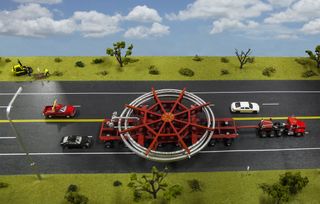 A truck had to be carefully designed to transport the Muon g-2 ring and its red stabilizing apparatus during the land legs at the beginning and end its journey — from Brookhaven to a barge and from the barge to Fermilab.